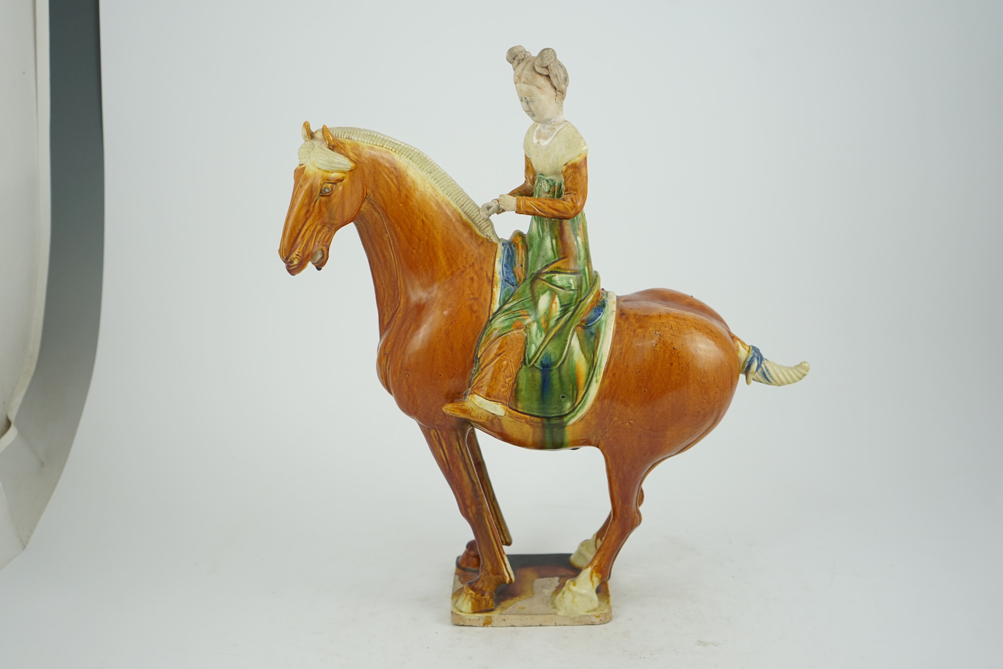 A Chinese sancai glazed group of a horse and female rider, Tang or later